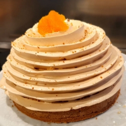 Petit gâteau en dôme recouvert d'un tourbillon de meringue italienne au caramel surplombé de quartiers d'agrumes pelés à vif